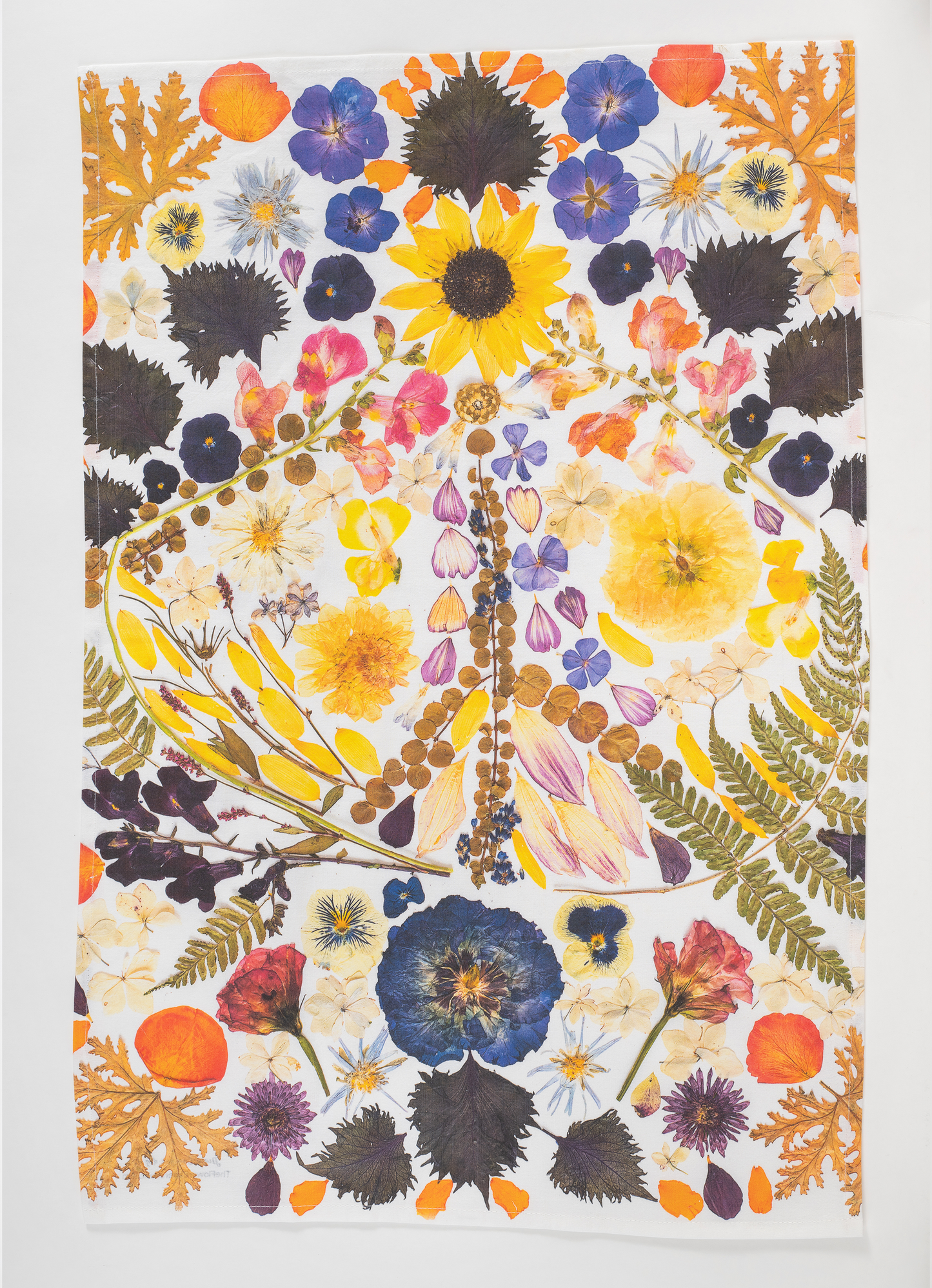 Pressed flower tea towel featuring botanical artwork created using flowers from the artists garden.