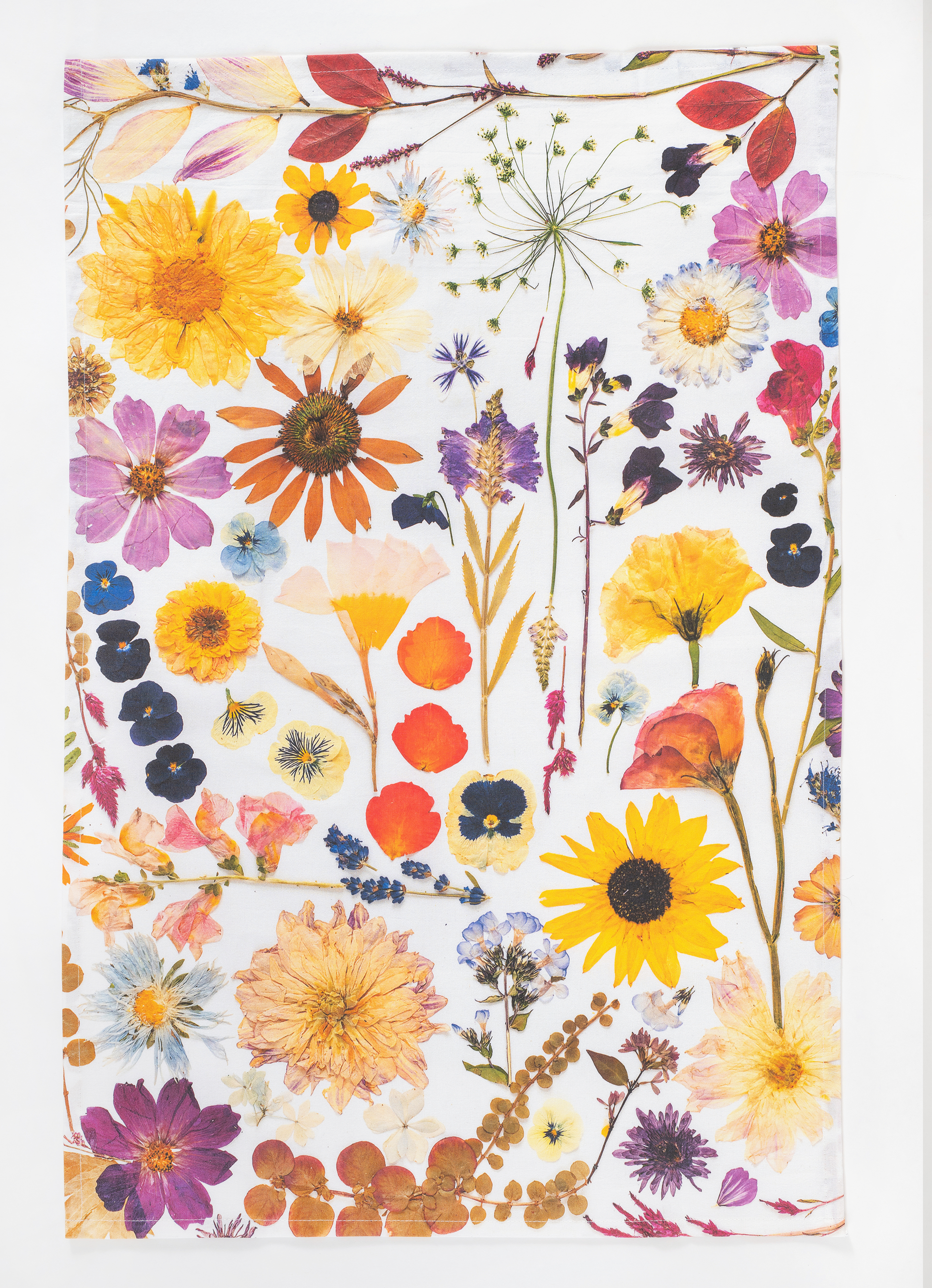 Pressed flower tea towel featuring botanical artwork created using flowers from the artists garden.
